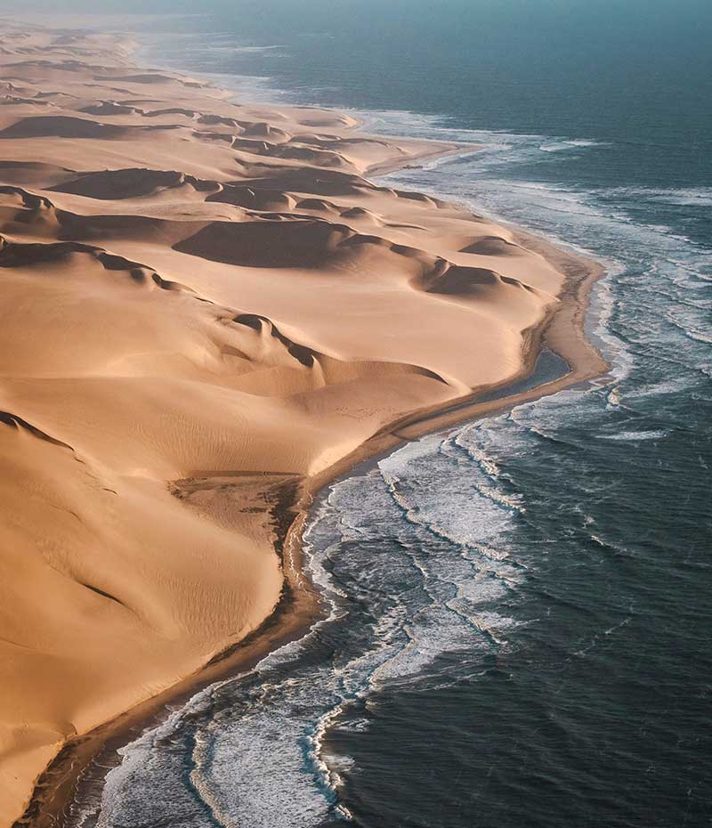 paisagem de Sandwich Harbour com dunas junto ao oceano Atlântico na Namíbia
