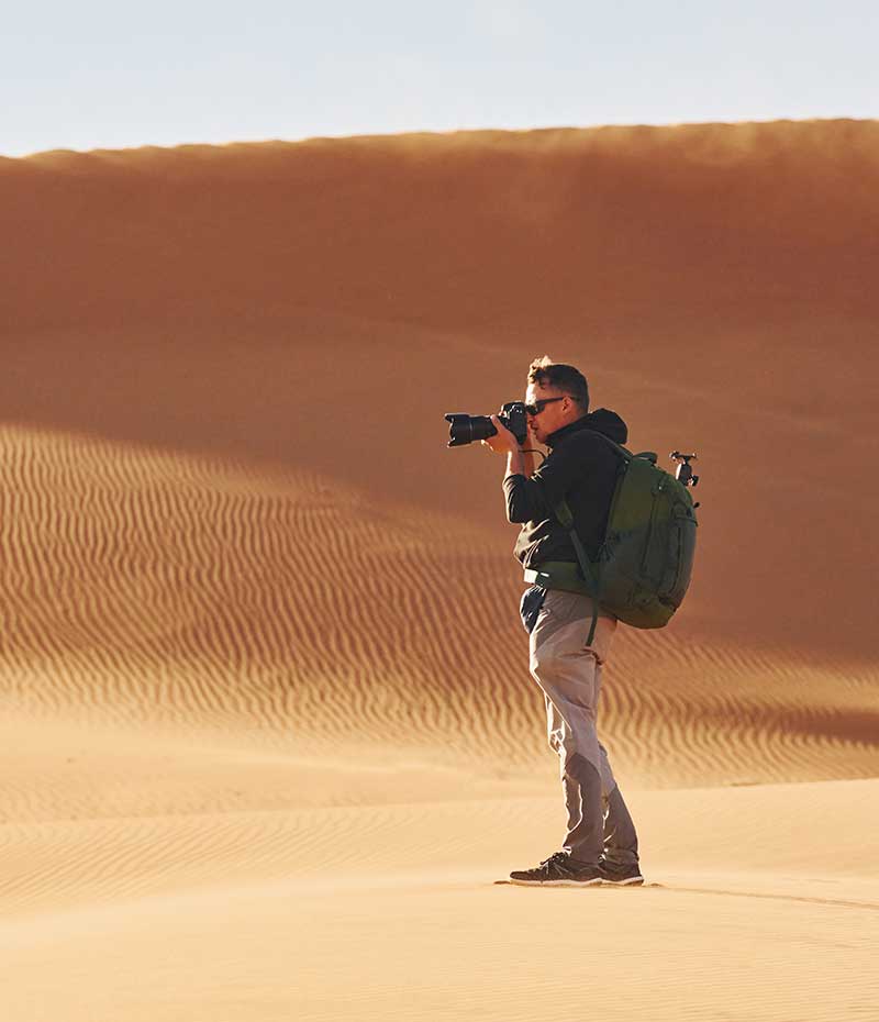 fotógrafo no deserto da Namíbia durante viagem