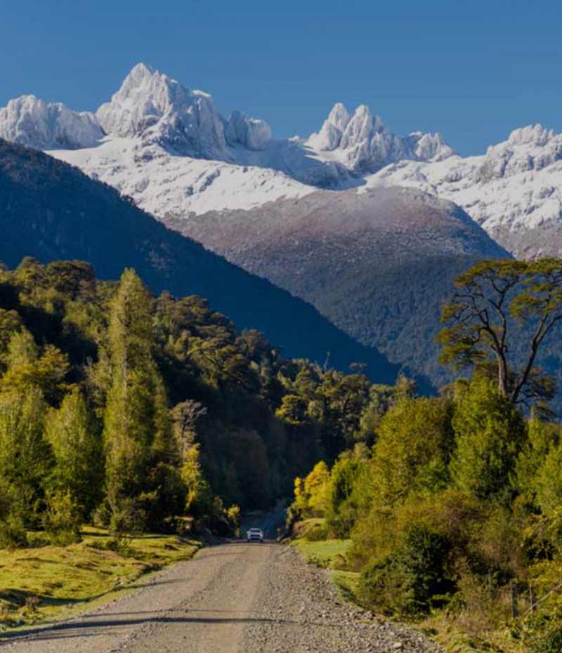 trecho da Carretera Austral cercado por montanhas com neve na Patagônia chilena