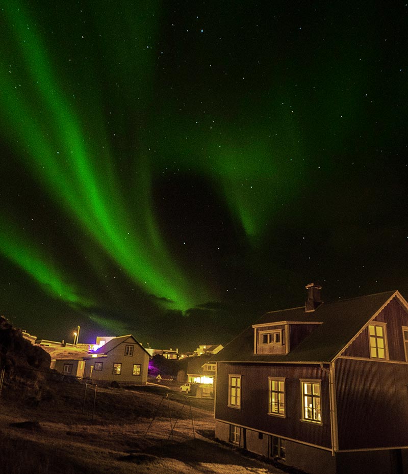 Aurora boreal na Islândia, com cabanas típicas