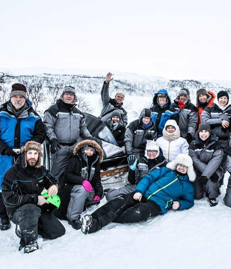 viajantes reunidos na neve durante experiência no Ártico