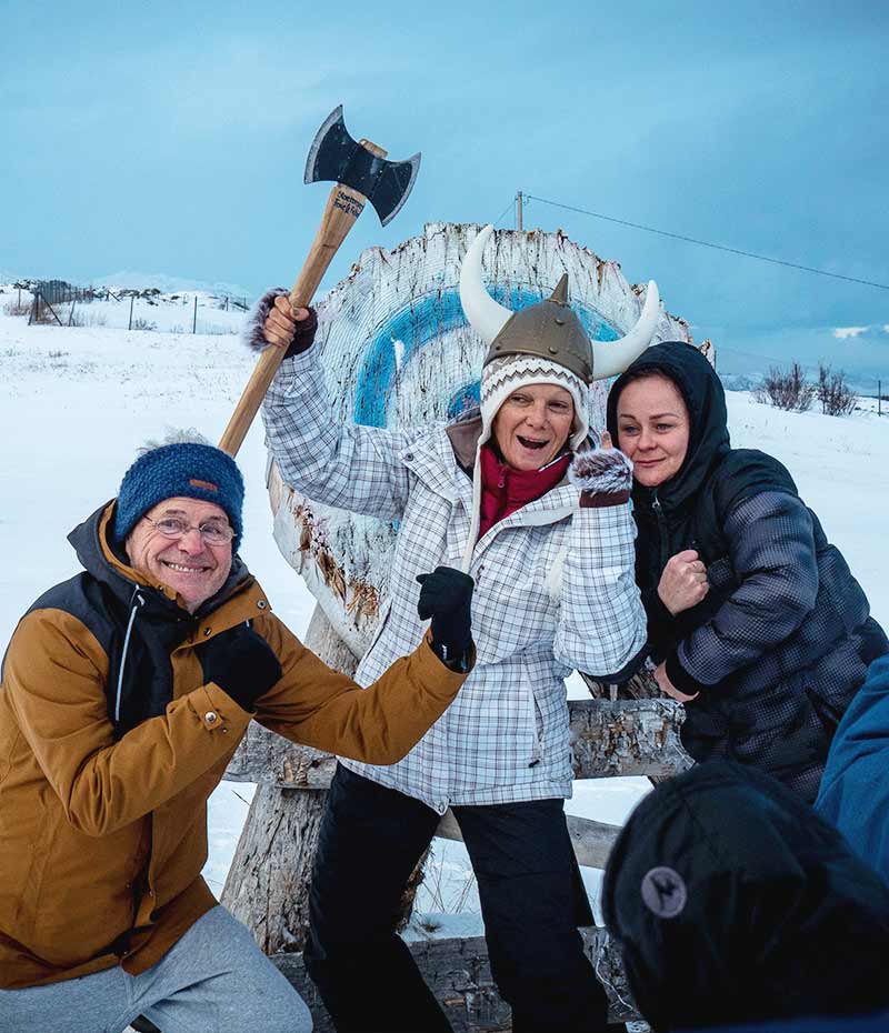 turistas na Noruega com machado viking em experiência cultural