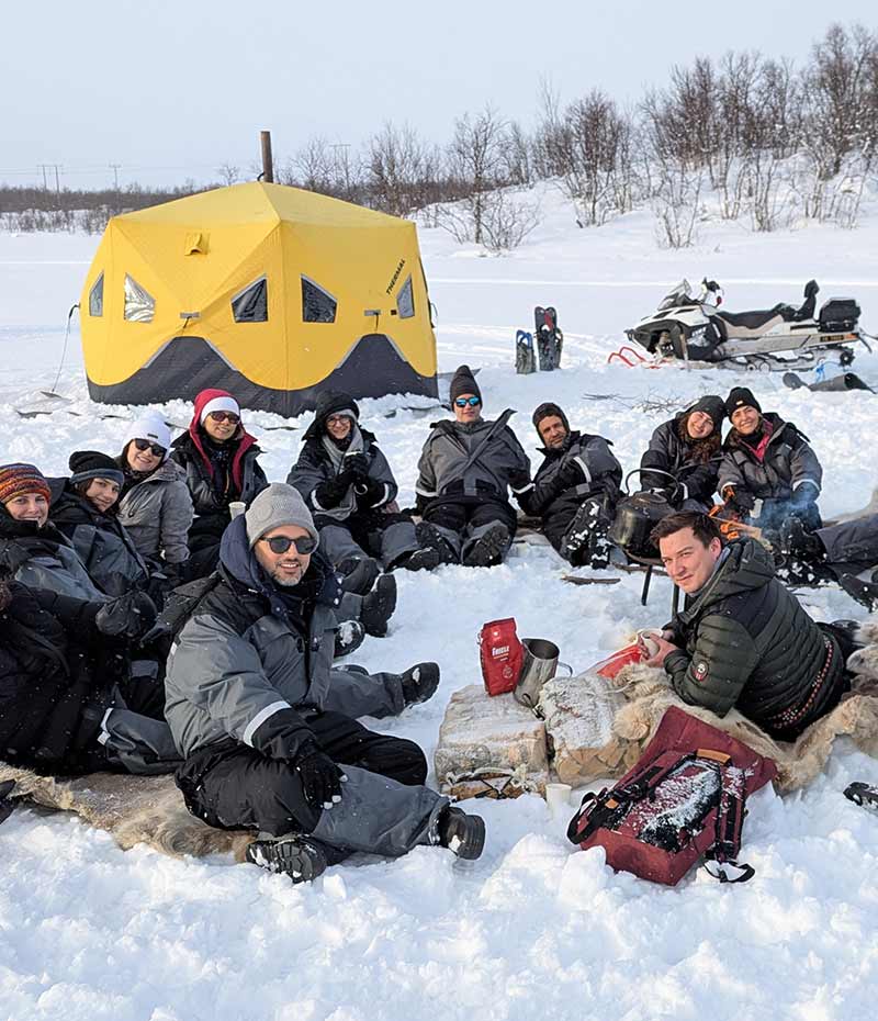 turistas sentados na neve na Noruega em paisagem ártica